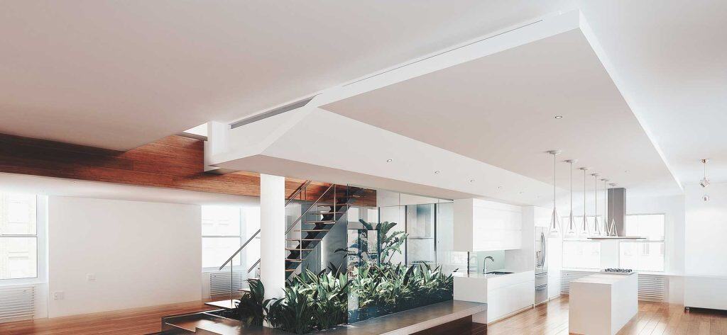 Elegant white ceiling with creative layers in kitchen and living area.