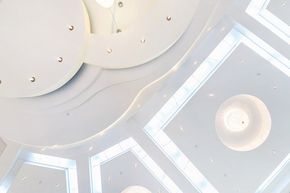Bright, clean ceiling with innovative lighting, perfect for upscale residential or commercial spaces.