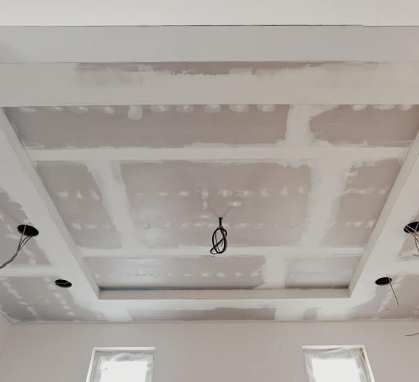 Ceiling renovation with drywall, patching, and recessed ceiling light wiring in progress for contemporary interior design.