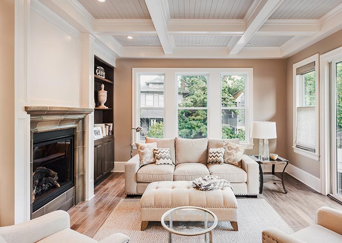 Bright cozy living room with stylish ceiling accents, large windows, and contemporary decor.