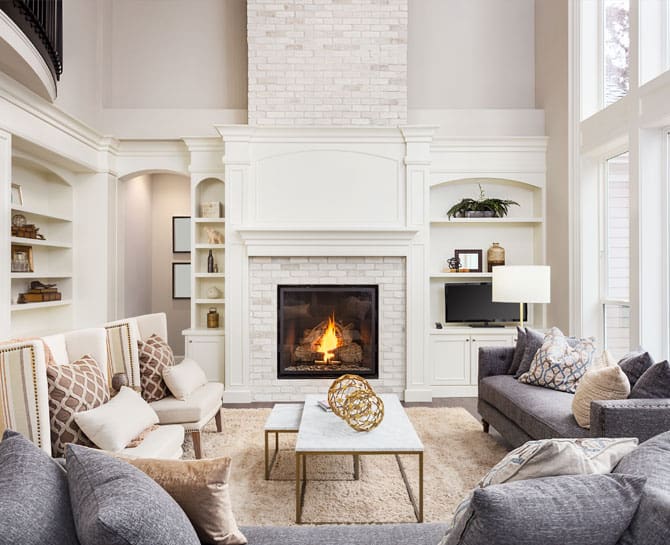 Elegant living room with white ceiling and fireplace, modern decor, and natural light.