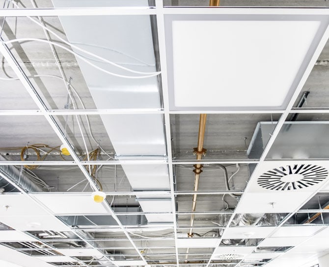 Modern ceiling installation with LED panels and ductwork in commercial space.
